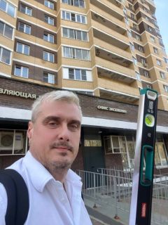 Марат с измерительным уровнем на фоне жилого дома